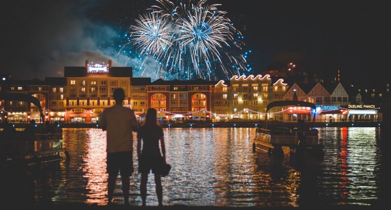 couple watching fireworks on a downtown river